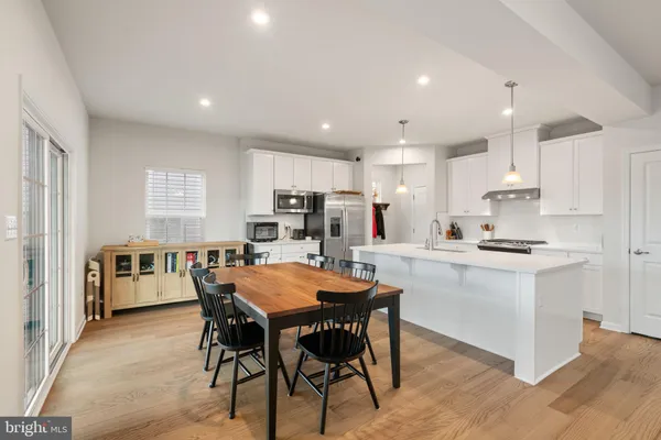 a kitchen with stainless steel appliances kitchen island a sink a stove a refrigerator and cabinets