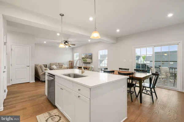 a kitchen with a dining table chairs and wooden floor