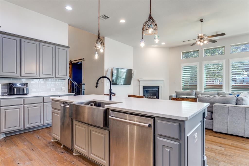 15193 Basket Oak Road Frisco, TX 75035 - Photo 39 of 40 a kitchen with cabinets a sink dishwasher a stove and a dining table with wooden floor
