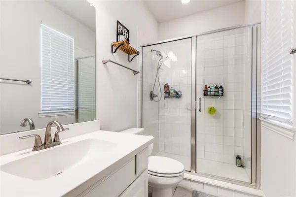 a spacious bathroom with a shower sink and mirror