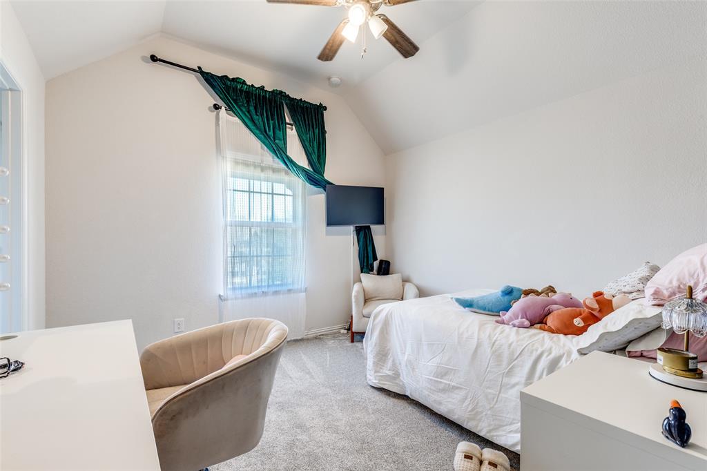 15193 Basket Oak Road Frisco, TX 75035 - Photo 20 of 40 a bedroom with a bed a couch and a chandelier