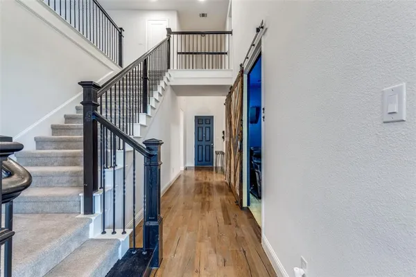 a view of entryway and gallery with wooden floor
