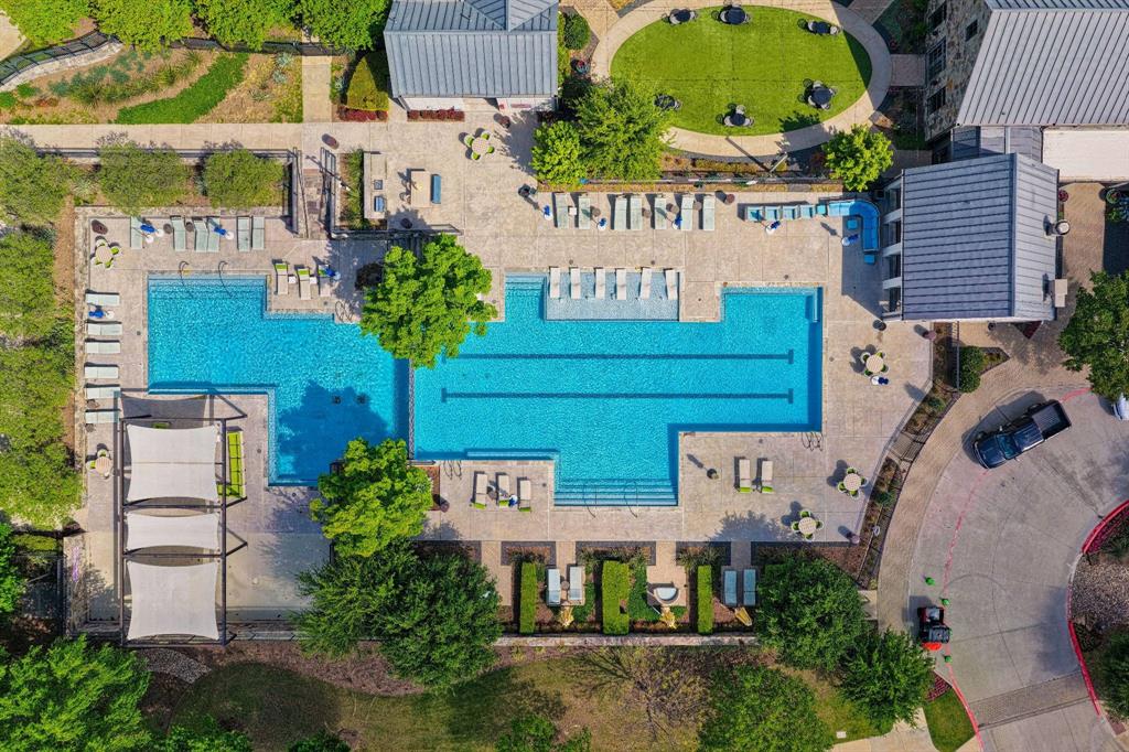 15193 Basket Oak Road Frisco, TX 75035 - Photo 32 of 40 The property features an extensive outdoor area with a multi-section swimming pool, paved lounging areas with chaise lounges and seating, and landscaped green spaces
