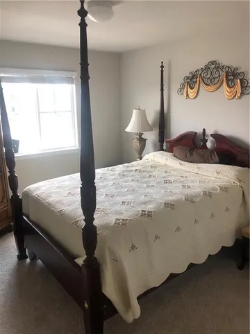 a bedroom with a bed and dresser next to a window