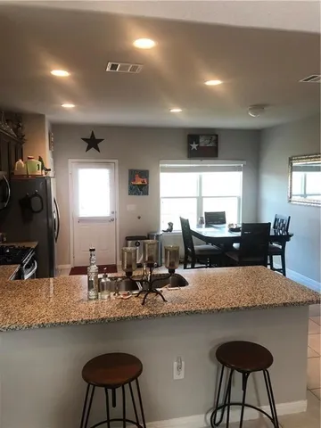 a kitchen with sink and chairs
