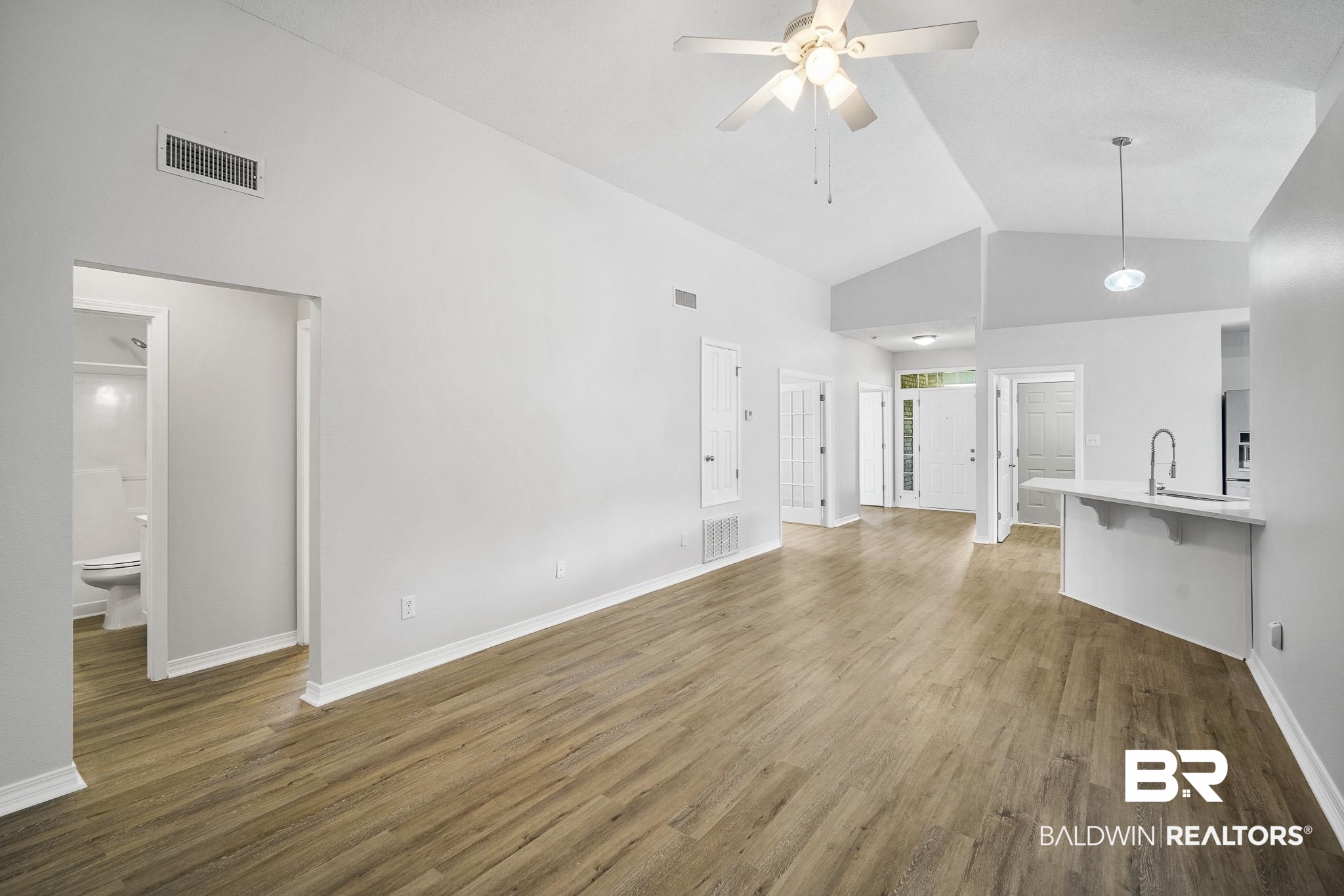 9814 Woolrich Avenue Fairhope, AL 36532 - Photo 9 of 29 Unfurnished living room featuring high vaulted ceiling, sink, ceiling fan, and hardwood / wood-style floors