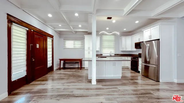 a kitchen with refrigerator cabinets and wooden floor