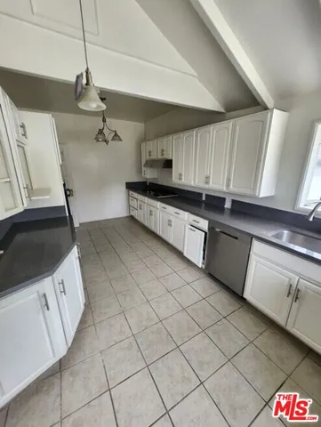 a kitchen with stainless steel appliances a sink a stove a microwave and a refrigerator