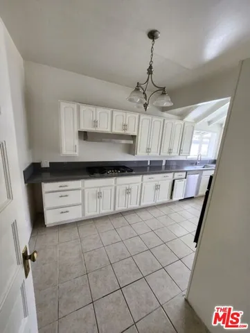 a kitchen with granite countertop white cabinets and stainless steel appliances