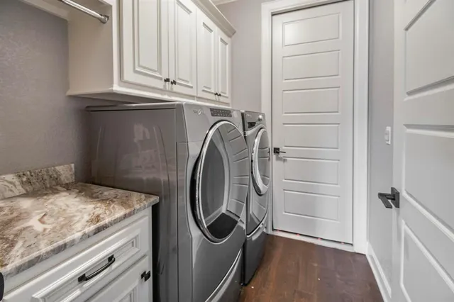 a utility room with granite countertop washer and dryer