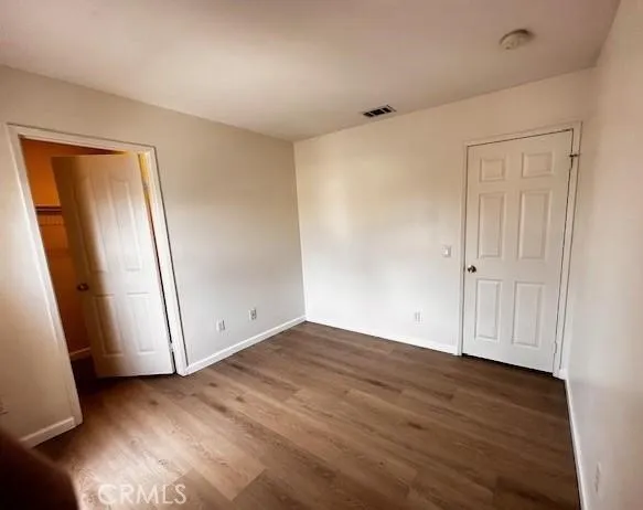 an empty room with wooden floor and mirror