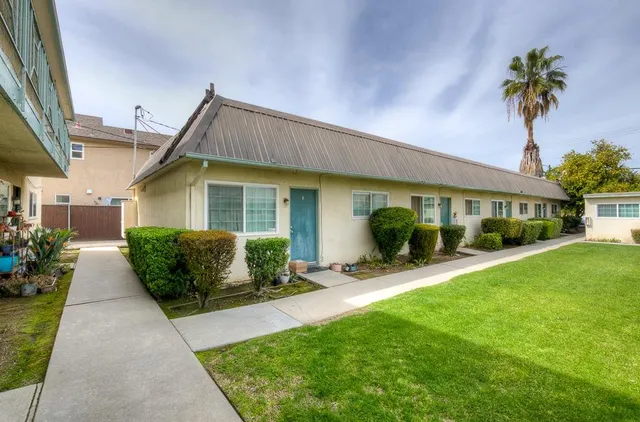 a front view of a house with a garden and plants