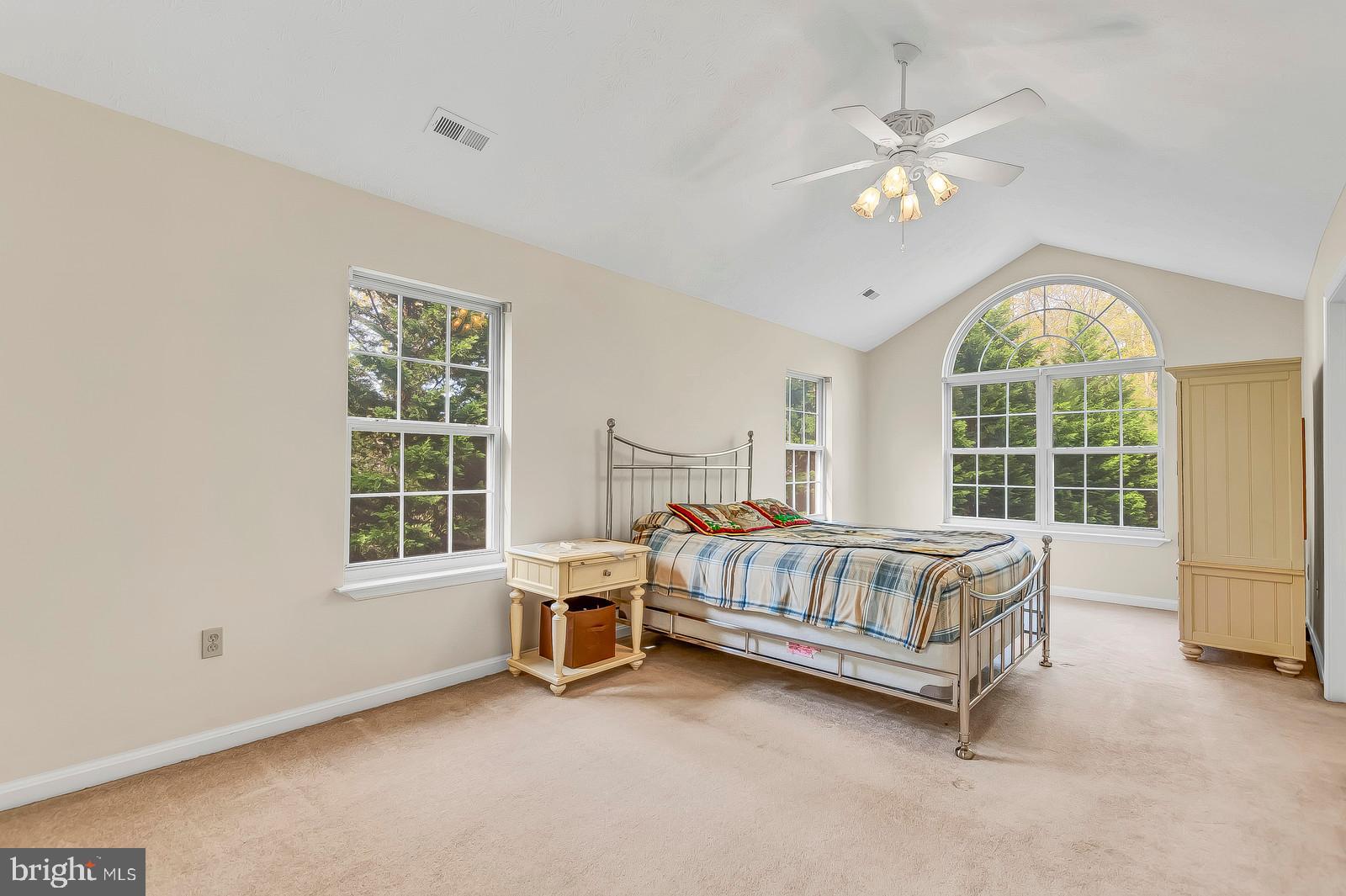 6815 Mackall Road St. Leonard, MD 20685 - Photo 15 of 38 a spacious bedroom with a bed and a chandelier