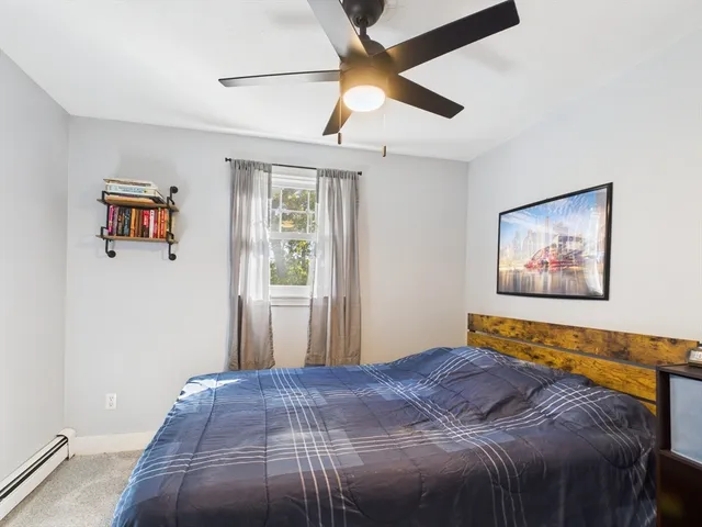 a bedroom with a bed and a painting on the wall