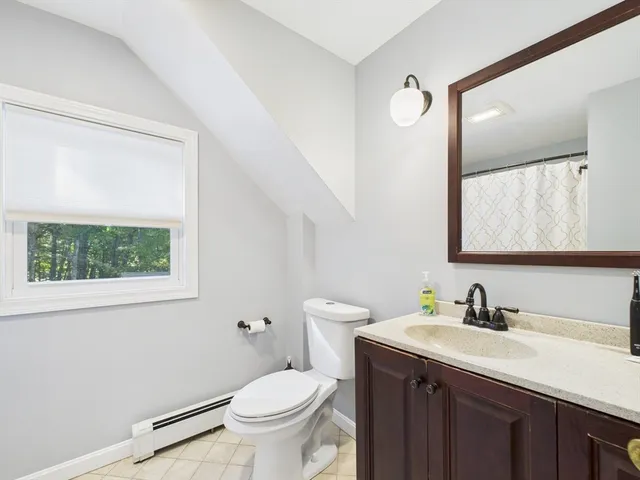 a bathroom with a granite countertop sink toilet and mirror
