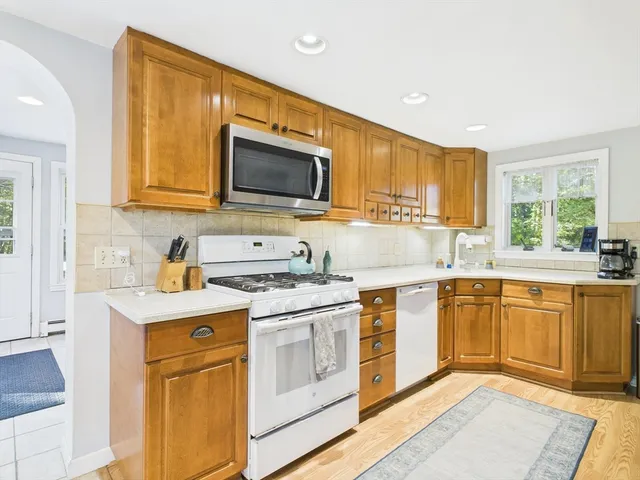 a kitchen with stainless steel appliances granite countertop a sink stove microwave and refrigerator