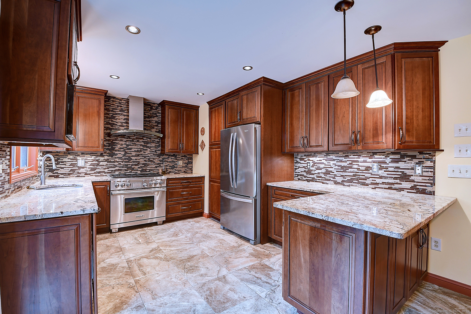 a kitchen with stainless steel appliances granite countertop a stove refrigerator sink and cabinets