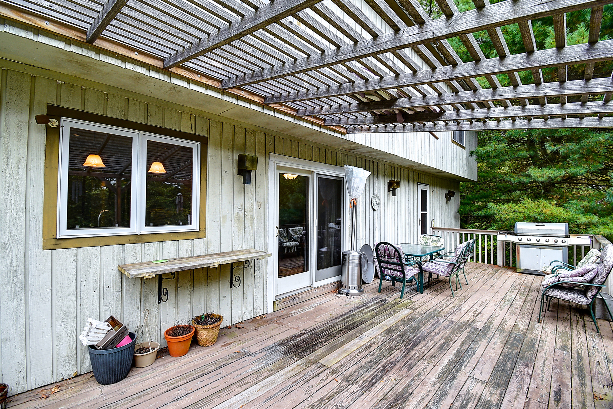 35 Weekeepeemee Road Bethlehem, CT 06751 - Photo 36 of 40 a view of a patio with table and chairs with wooden floor and fence