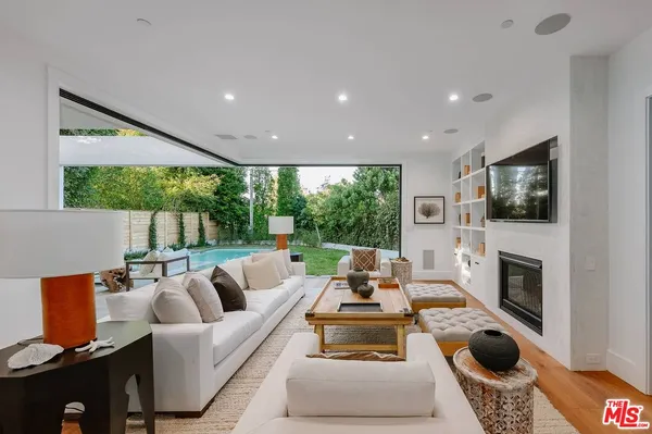 a living room with furniture a flat screen tv and a fireplace