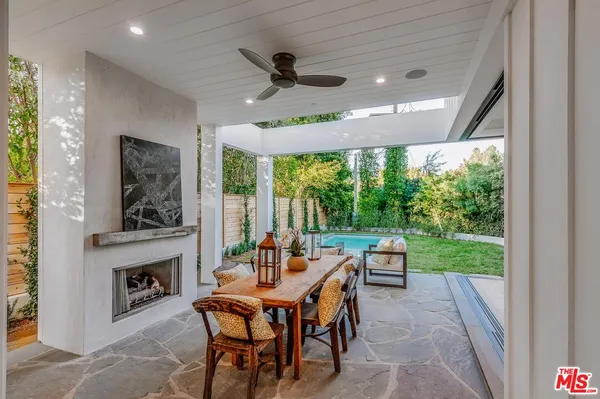 a dining room with furniture a fireplace and a floor to ceiling window