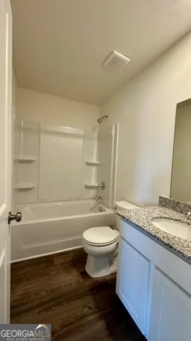 a bathroom with a sink a toilet a mirror and bathtub