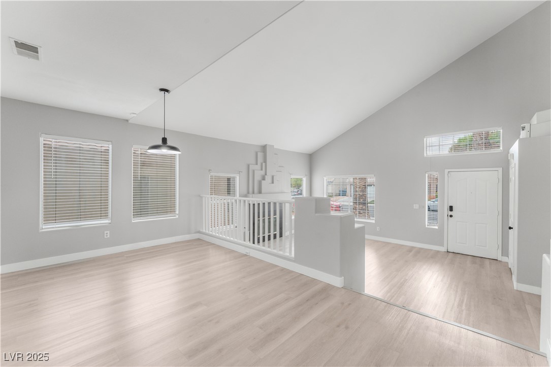 3695 Funston Way Las Vegas, NV 89129 - Photo 13 of 43 Unfurnished living room with high vaulted ceiling and light wood-style flooring