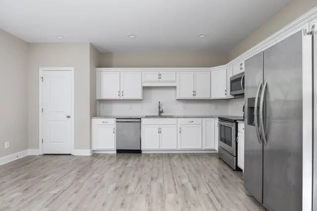 a kitchen with a refrigerator sink and cabinets