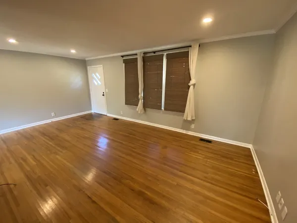 a view of an empty room with wooden floor