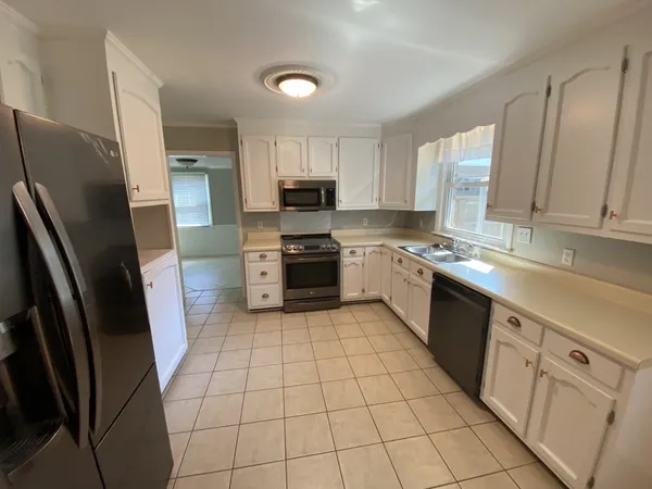 a kitchen with stainless steel appliances a refrigerator sink and microwave