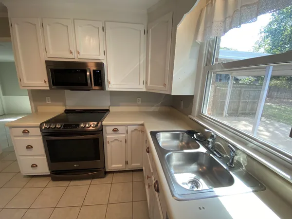a kitchen with granite countertop a stove and a sink