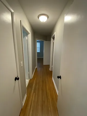 a view of a hallway with wooden floor and staircase