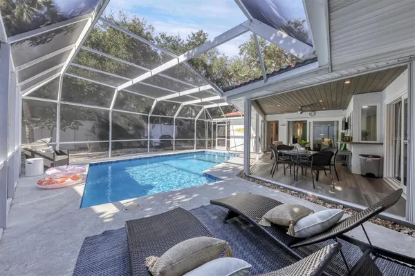 a view of a patio with couches chairs and wooden floor