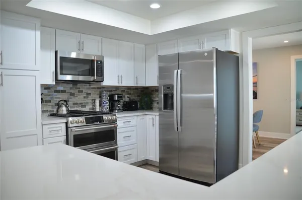 a kitchen with stainless steel appliances granite countertop a refrigerator stove and sink