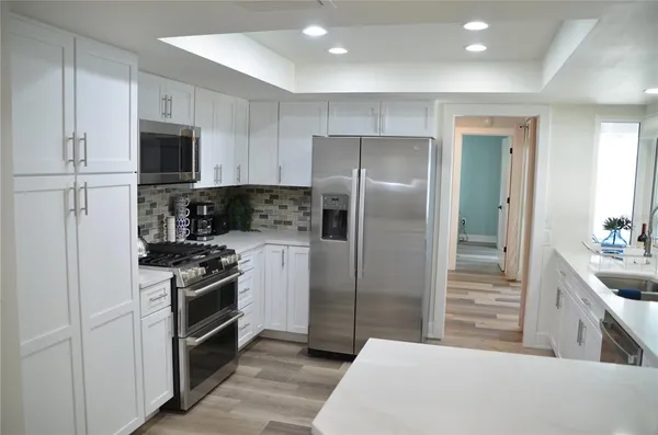 a kitchen with a sink a refrigerator and cabinets