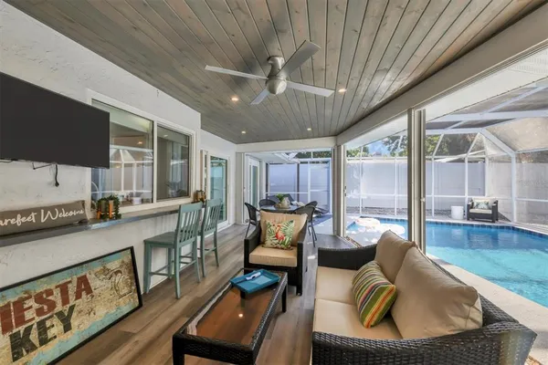 a living room with furniture a flat screen tv and a floor to ceiling window