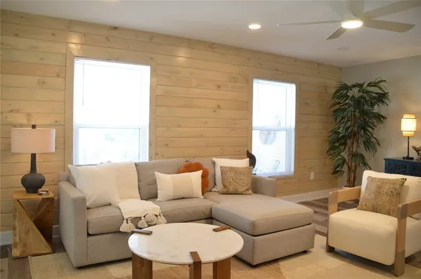 a living room with furniture a window and a potted plant