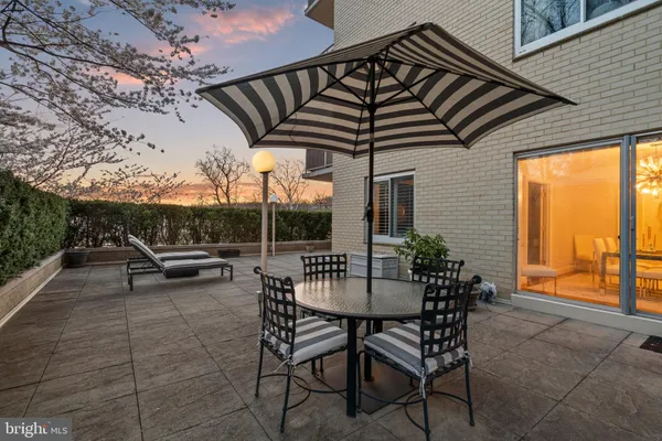 a patio with table and chairs and potted plants