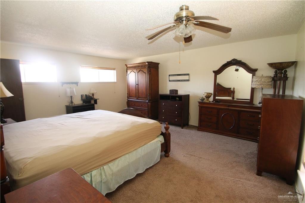 110 Avenida Morelos Rancho Viejo, TX 78575 - Photo 13 of 19 a spacious bedroom with a bed and dresser with mirror