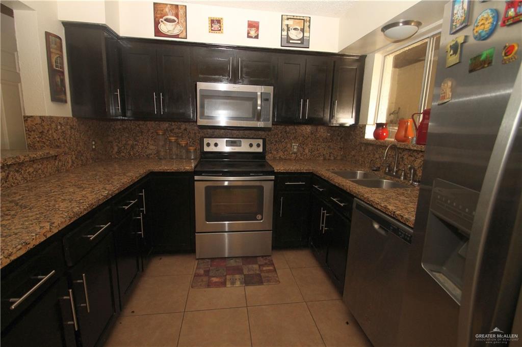 110 Avenida Morelos Rancho Viejo, TX 78575 - Photo 3 of 19 a kitchen with stainless steel appliances granite countertop a stove a sink and a microwave