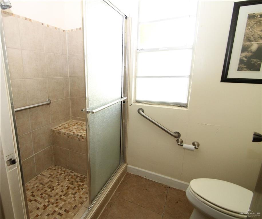 110 Avenida Morelos Rancho Viejo, TX 78575 - Photo 6 of 19 a bathroom with a granite countertop shower and a toilet