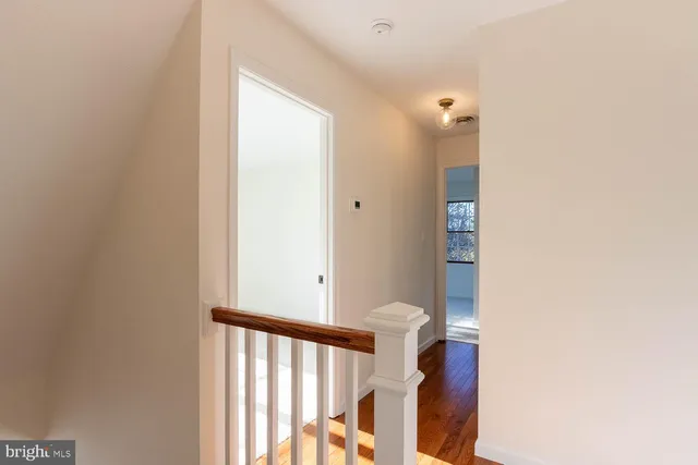 a view of a hallway with wooden floor and entryway