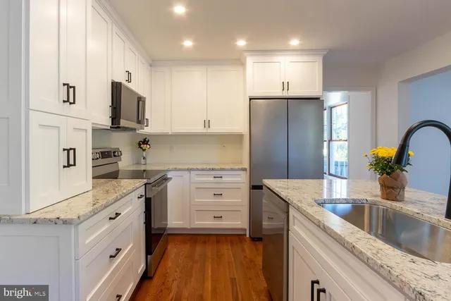 a kitchen with white cabinets and stainless steel appliances