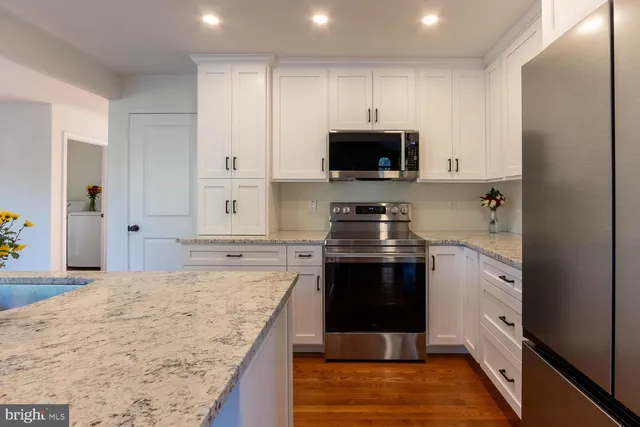 a kitchen with stainless steel appliances granite countertop a stove a sink and a microwave