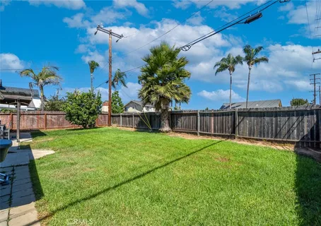 a view of a white house in front of a yard
