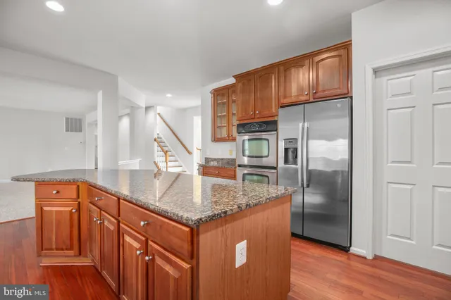 a kitchen with stainless steel appliances granite countertop a stove a sink and a refrigerator
