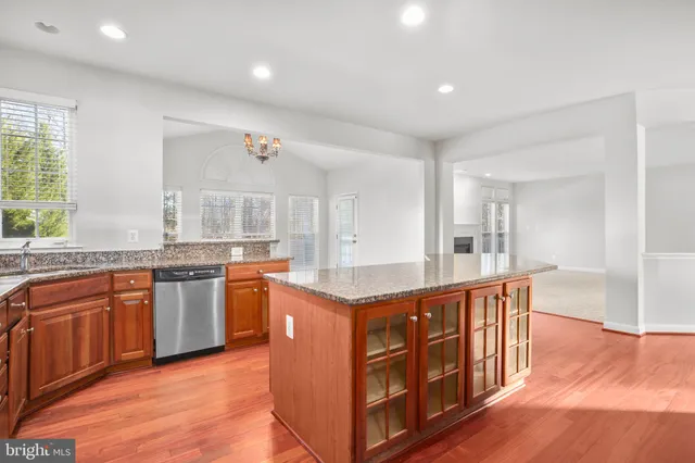 a view of an empty room with a kitchen and a window