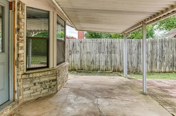 a view of a backyard with potted plants and wooden fence