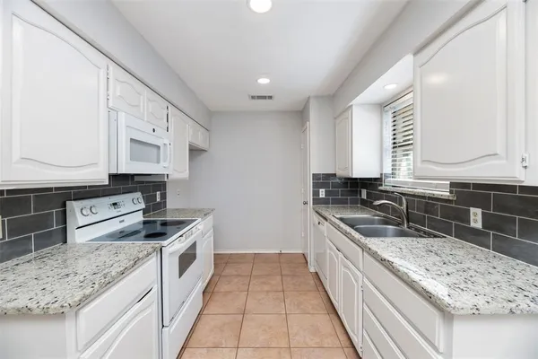 a large kitchen with stainless steel appliances granite countertop a sink stove and cabinets