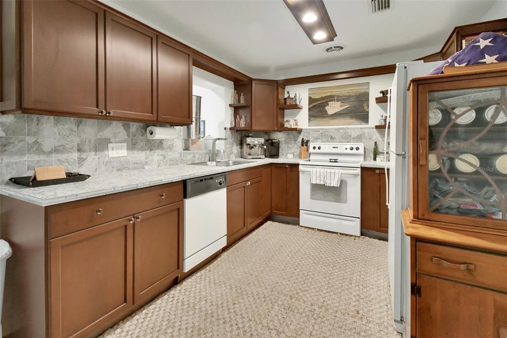 22040 Blue Creek Lodge Road Astor, FL 32102 - Photo 13 of 42 a kitchen with stainless steel appliances granite countertop a stove sink and cabinets