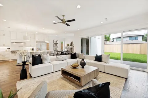 a living room with furniture and a view of kitchen